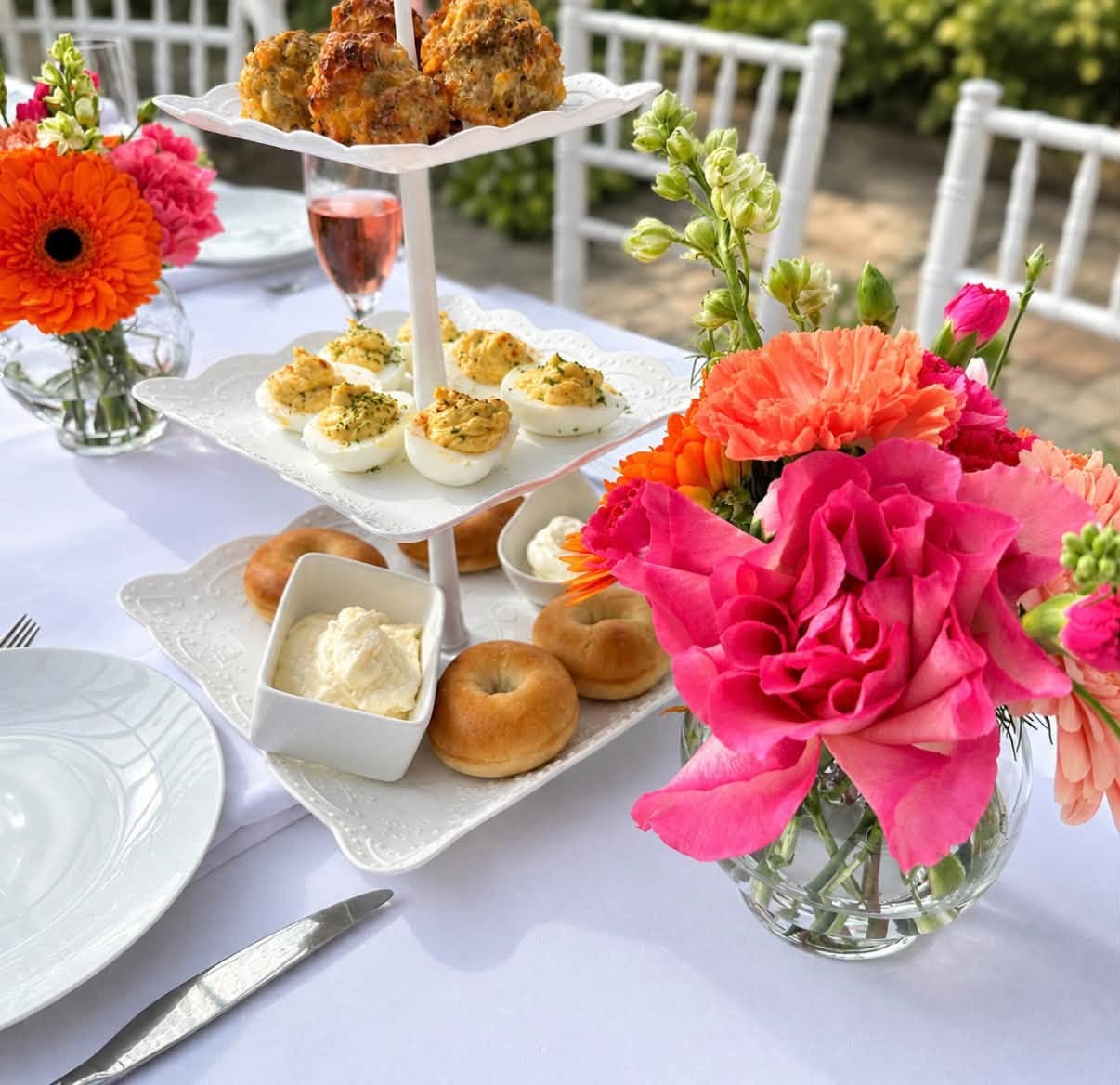 Bright floral table arrangement beside a tea service