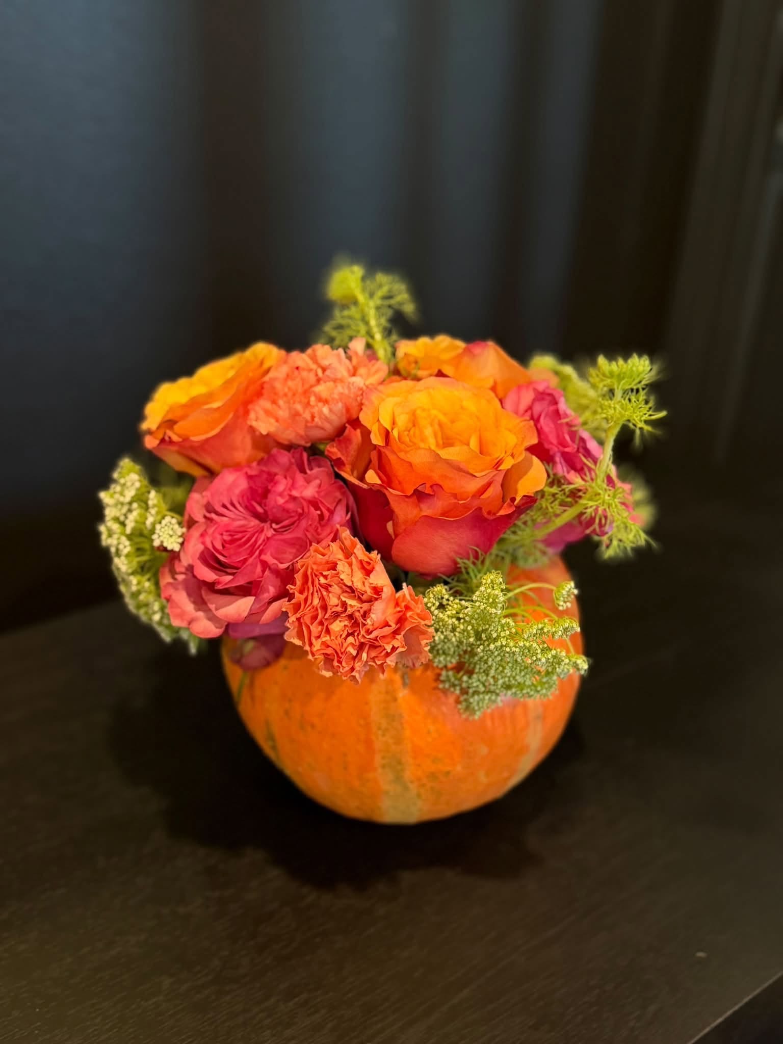 Pink and orange blooms in an orange pumpkin