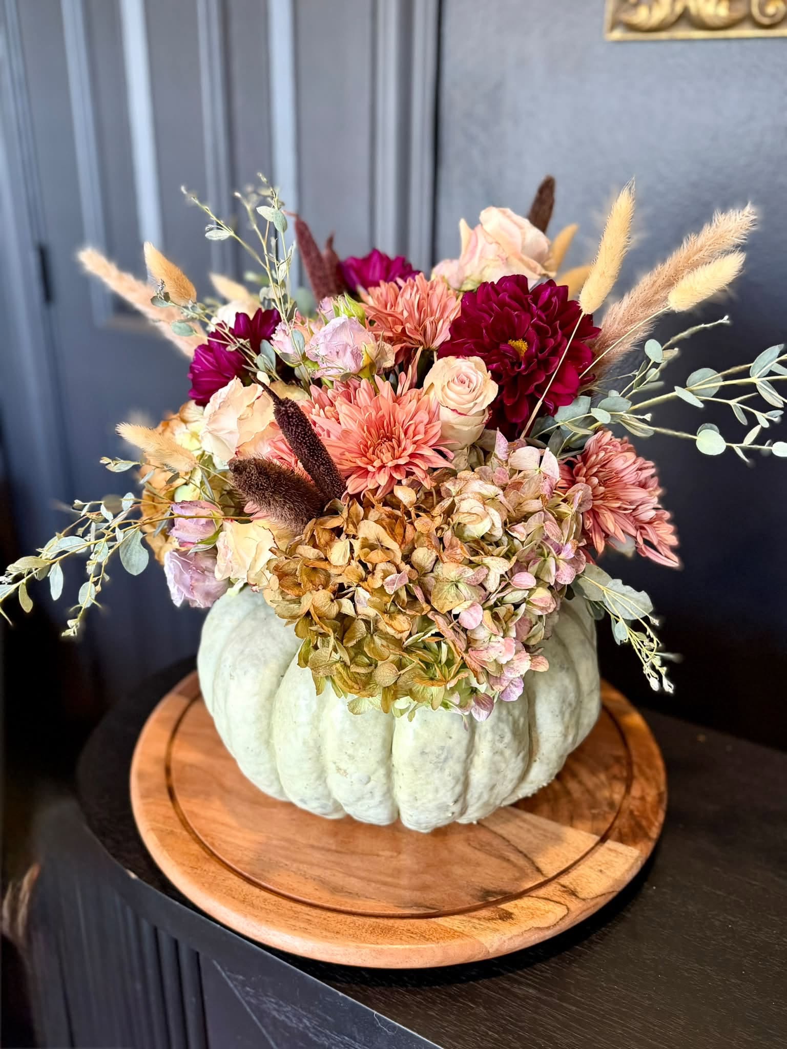 Soft pink and cream flowers in a pumpkin vessel